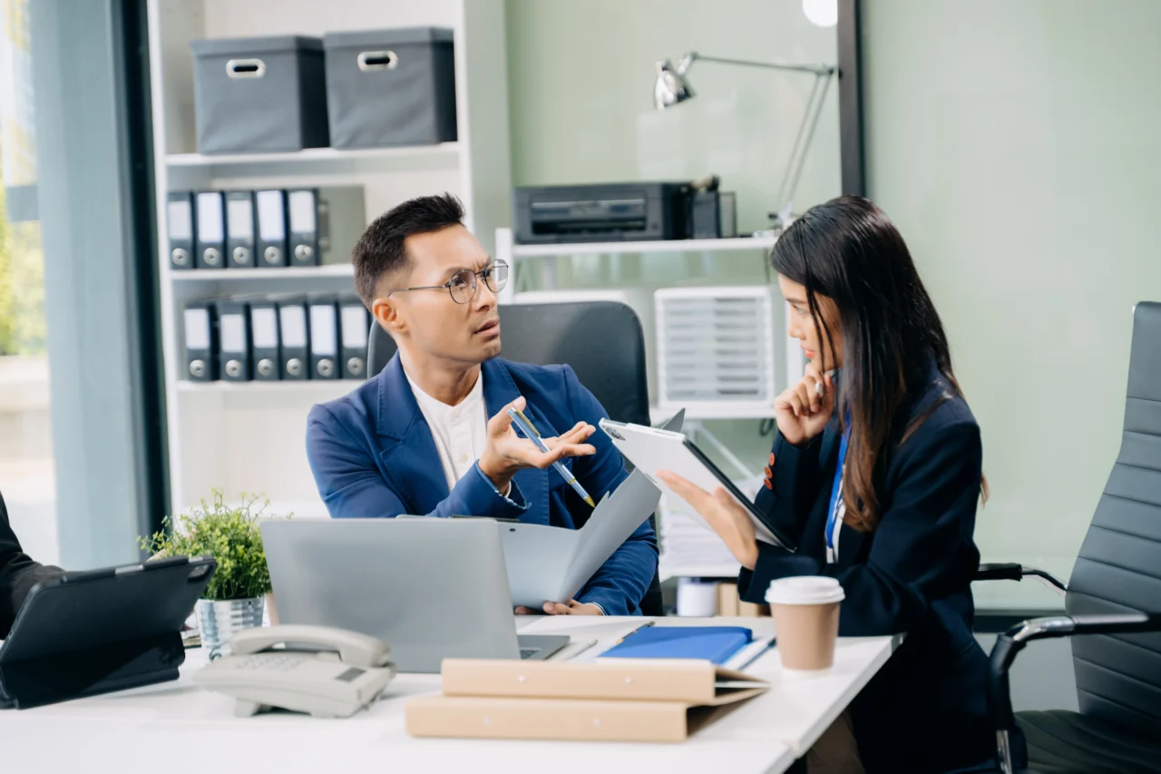 HR professional reviewing an employee leave and accommodation request in an office meeting.